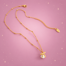 Bow & Bead Necklace on a dusty rose background with rose gold sparkles