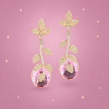 Golden Leaf Drop Earrings on a dusty rose background with rose gold sparkles