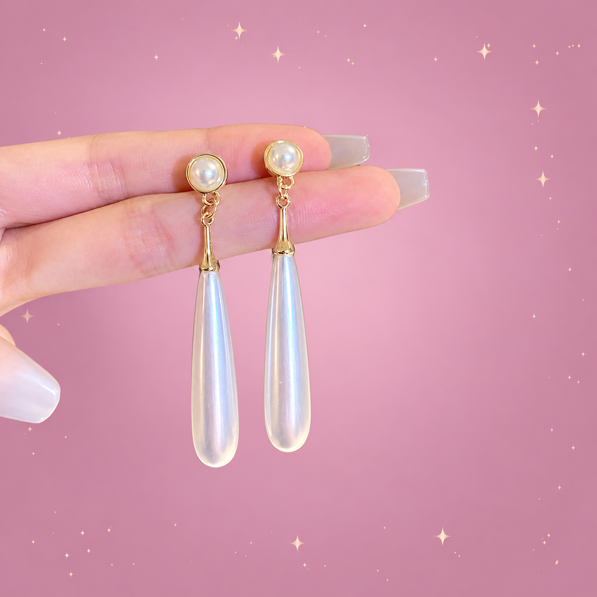 Long Teardrop Earrings on a dusty rose background with rose gold sparkles